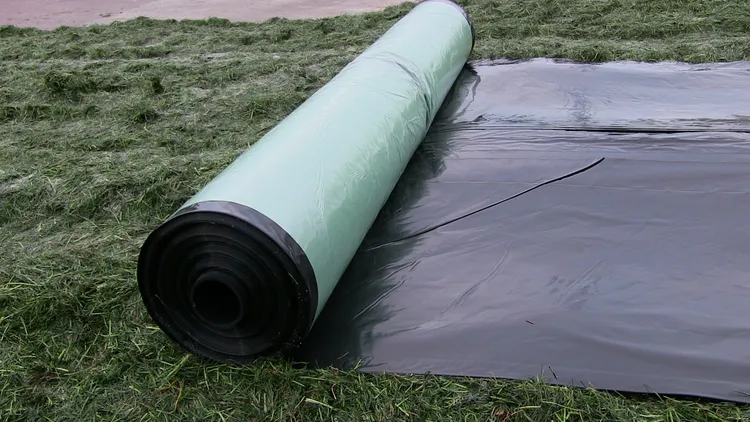 Plastic uitrollen over graskuil - VisscherHolland